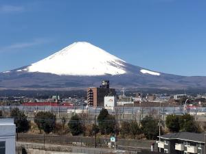 une montagne enneigée devant une ville dans l'établissement Hotel Lumiere Gotenba (Adult Only), à Gotemba