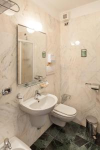 a bathroom with a sink and a toilet and a mirror at Hotel Granduca SPA & Parking in Grosseto