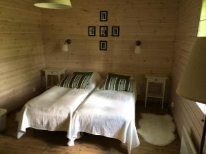 a bedroom with a white bed and two tables at Ollilan tupa Joensuun lähellä in Ylämylly
