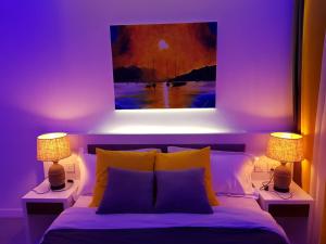 a bedroom with a bed with two lamps and a painting at Studio 103, Ebene Square in Ebene