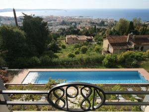 een uitzicht op een zwembad vanuit een huis bij Maison de charme avec imprenable vue mer, magnifique piscine et climatisation in Vallauris