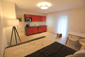 een kamer met een bed en een keuken met rode kasten bij Villa Parasana in Gordevio
