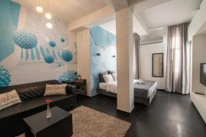 a living room with a couch and a bed at 27Montefiore - Urban ApartHotel TLV in Tel Aviv