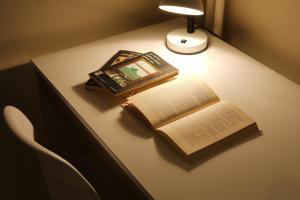 un libro aperto su un tavolo con una lampada e un quadro di Aristotle's studio apartment ad Atene