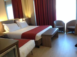 a hotel room with two beds and a tv at Cardano Hotel Malpensa in Cardano al Campo