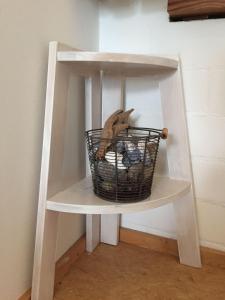 a white shelf with a bird in a basket on it at drunter-drueber-Maisonette-Ferienwohnung-Luebecker-Bucht in Scharbeutz