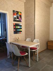 a dining room table with chairs and a painting on the wall at drunter-drueber-Maisonette-Ferienwohnung-Luebecker-Bucht in Scharbeutz