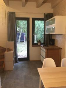 a kitchen with two windows and a table with chairs at drunter-drueber-Maisonette-Ferienwohnung-Luebecker-Bucht in Scharbeutz