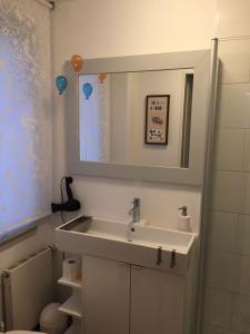 ein Bad mit einem Waschbecken und einem Spiegel in der Unterkunft "drunter & drüber" Maisonette Ferienwohnung Lübecker Bucht in Scharbeutz