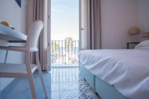 a bedroom with a bed and a chair and a balcony at B&B Il Castello in Lipari