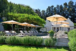 Franschhoek的住宿－薰衣草農場旅館，一个带椅子和遮阳伞的庭院