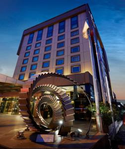 een gebouw met een spiraalvormig beeld ervoor bij Avantgarde Hotel Levent in Istanbul