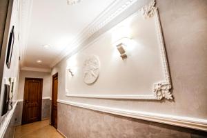 Un pasillo con una pared blanca con un espejo. en Funny Holiday, en Roma