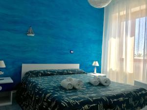 マンフレドーニアにあるDivino Bed & Breackfastの青いベッドルーム(タオル付きのベッド付)