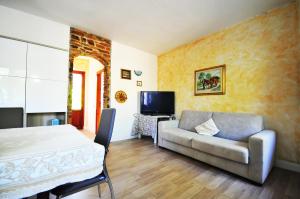 a living room with a couch and a television at RESIDENZA I MELOGRANI in Porto Ottiolu