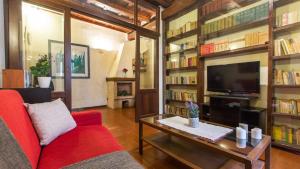 ローマにあるRental in Rome Luce Apartmentのリビングルーム(赤いソファ、テレビ付)