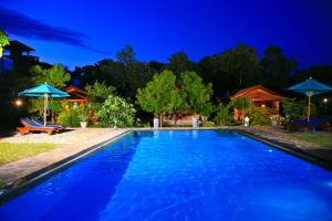 a swimming pool in a backyard at night at Shangri-Lanka Village in Tissamaharama