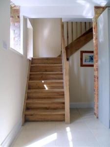 Una escalera en una casa con escalones de madera en Toad Hall at Tove Valley Cottages en Towcester