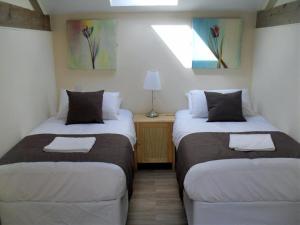 2 Betten in einem kleinen Zimmer mit in der Unterkunft Toad Hall at Tove Valley Cottages in Towcester