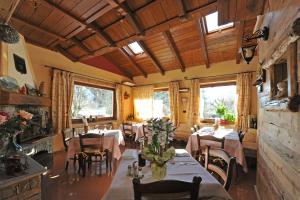 a dining room with tables and chairs and windows at Hotel Des Roses in Antey-Saint-André