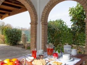 Al Guado di Assisi B&B في باستيا أومبرا: طاولة في الهواء الطلق مع الفاكهة والمشروبات على الفناء