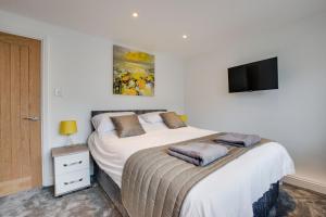 um quarto com uma cama e uma televisão na parede em Hafan y Ddinas Cardiff Apartment 1 em Cardiff