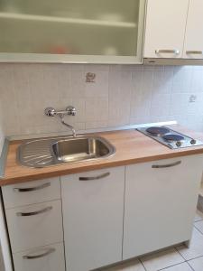 a kitchen with a sink and white cabinets at Accommodation Drasko in Korčula