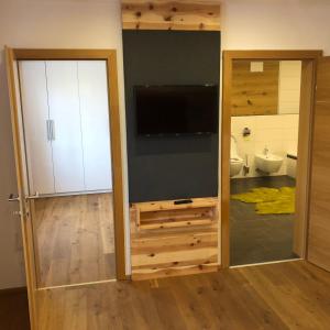 baño con TV y puerta corredera en Vine & Design, en Langenlois