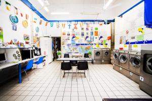 a laundry room with two washers and two tables and chairs at Funny Palace Hostel in Rome