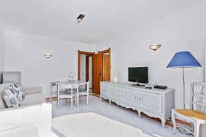 een witte woonkamer met een tv en een bank bij AZUL/MAR ALBUFEIRA 602 in Albufeira