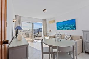 een keuken en woonkamer met een tafel en stoelen bij AZUL/MAR ALBUFEIRA 602 in Albufeira