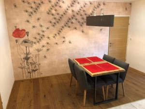 a dining room with a table with chairs and flowers on the wall at Vine & Design in Langenlois
