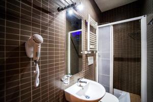 bagno con lavandino, servizi igienici e specchio di Funny Palace Hostel a Roma
