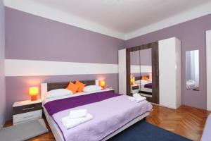 a bedroom with a large bed and a mirror at Apartments Santin in Rovinj