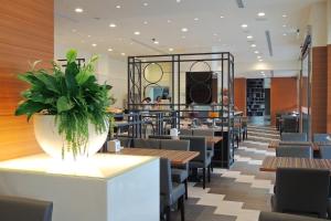 a restaurant with tables and chairs and a plant at C U Hotel Taichung in Taichung