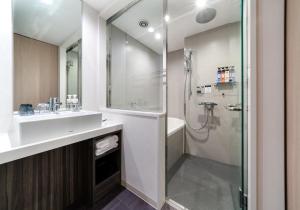 a bathroom with a sink and a shower at Daiwa Roynet Hotel Hiroshima-ekimae in Hiroshima +40 photos