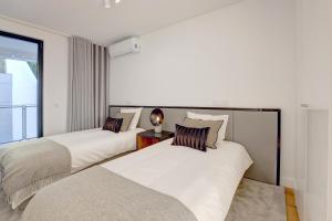 Duas camas num quarto com uma janela em Luxury Graça Apartment The Most Amazing View of Lisbon em Lisboa