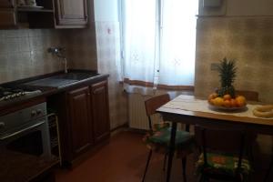 eine Küche mit einem Tisch mit einer Obstschale darauf in der Unterkunft PRIONE70 in La Spezia