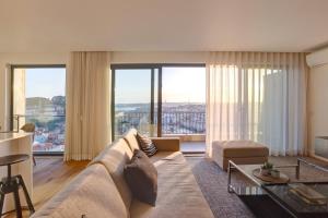 a living room with a large couch and large windows at Luxury Graça Apartment The Most Amazing View of Lisbon in Lisbon