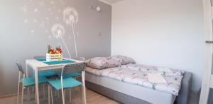 a small room with a bed and a table with a cake at GreatHome Apartament in Zator