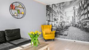 salon z kanapą i żółtym krzesłem w obiekcie Maya's Flats & Resorts 19 & 20 - Ogarna w Gdańsku