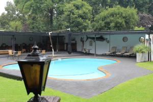 a swimming pool in a yard with a patio at Lauriston Guesthouse in Centurion