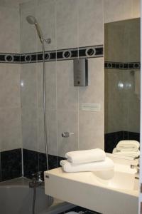 ein Badezimmer mit einer Dusche, einem Waschbecken und einer Badewanne in der Unterkunft Hotel Blanc in Marigny-Saint-Marcel