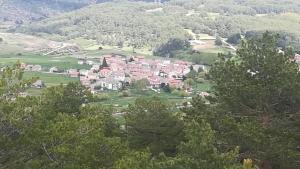 un grupo de casas en una colina con árboles en Hotel El Molino en Bezas