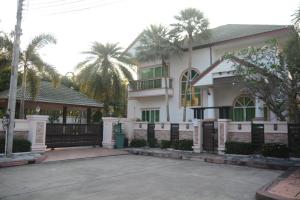 een wit huis met een poort en palmbomen bij 4 Bedroom Beachfront Pool House in Na Jomtien