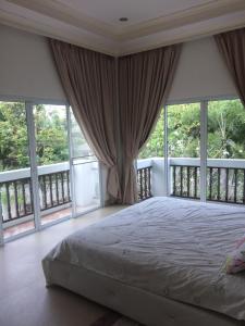een slaapkamer met een bed en grote ramen bij 4 Bedroom Beachfront Pool House in Na Jomtien