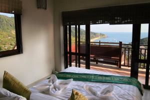 a bedroom with a bed with a view of the ocean at Baan KanTiang See Villas - SHA Extra Plus in Ko Lanta