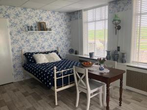 a bedroom with a bed and a table with a dining room at B&B Beemsterlust in Westbeemster