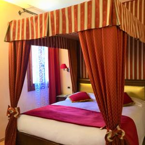 a bedroom with a canopy bed with red curtains at Residenza Rivo Alto in Venice