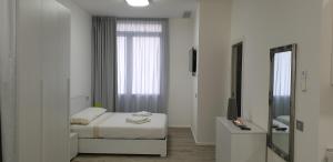 Habitación blanca con cama y espejo en Appartamento La Bottega, en Piove di Sacco